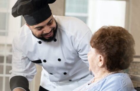 Chef smiling down on senior living resident