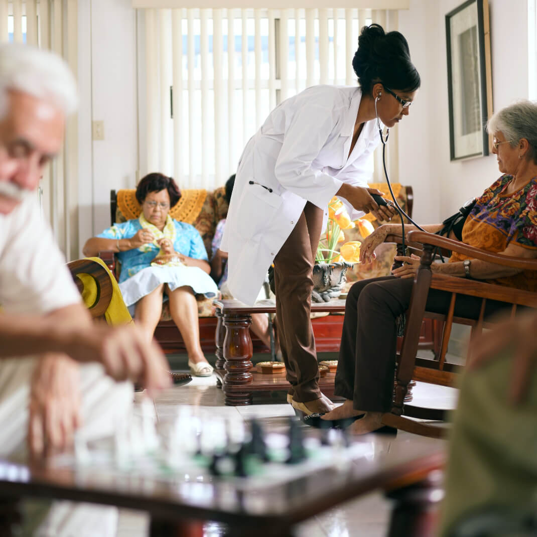 Female healthcare professional taking blood pressure of older woman
