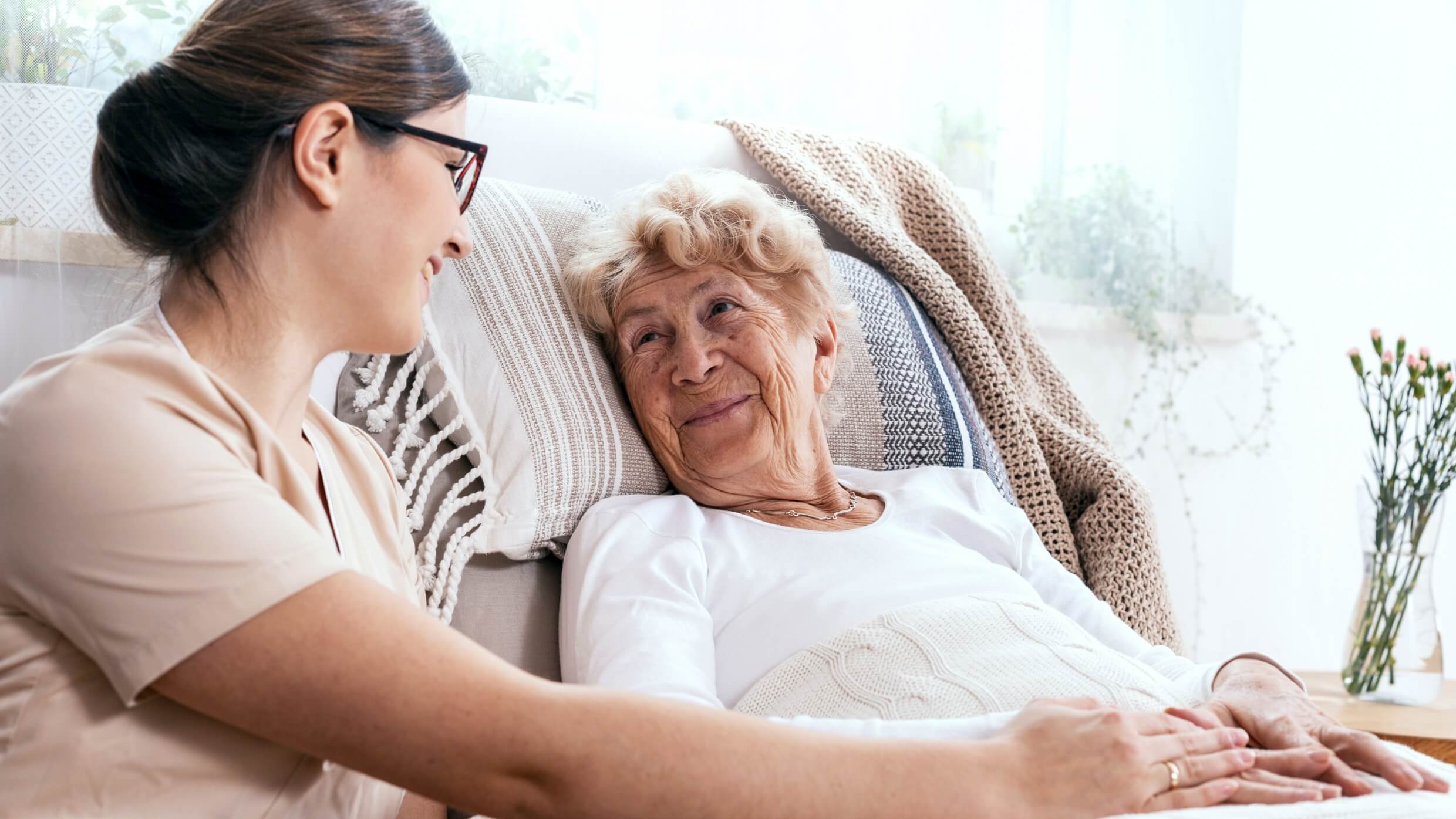 Female caregiver supporting older female