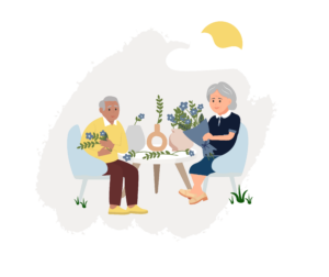 two seniors sit at a table making floral arrangements