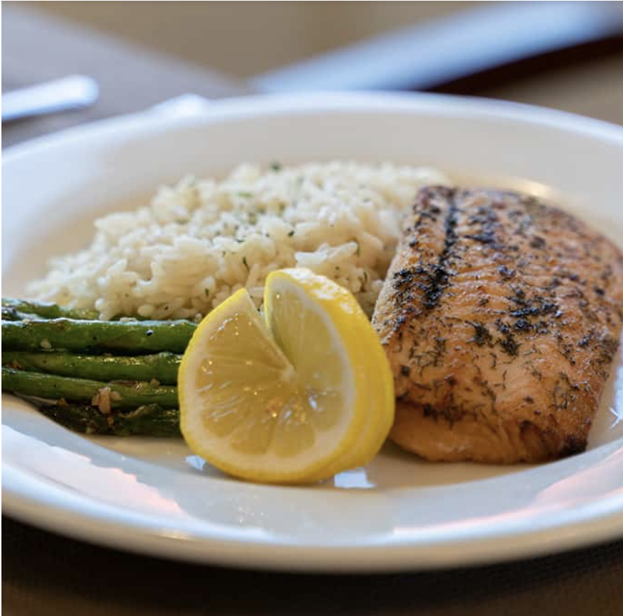 Close up of plated meal, salmon, asparagus, rice with lemon